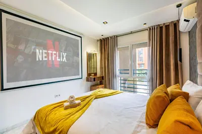 a bedroom with a bed with a television on the wall at Luxury CINÉMA-BEDROOM AK04 Guéliz-TopCenter in Marrakech