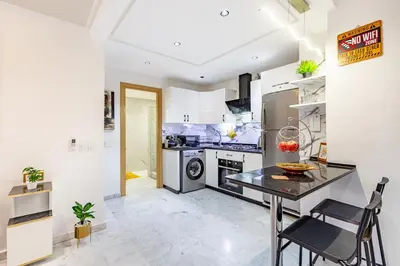 a kitchen with a table and a stove at Luxury CINÉMA-BEDROOM AK04 Guéliz-TopCenter in Marrakech