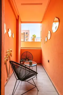 an orange room with a chair and a table at HS14 Luxury 2Chambres Gueliz TopCenter in Marrakech