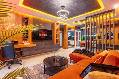 a living room with orange furniture and a tv at Cinéma Pool Unique Experience Mkesh Top10 in Marrakech
