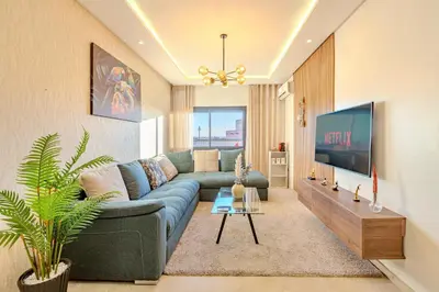 a living room with a blue couch and a tv at GUELIZ city center Perfect location with nice view in Marrakech