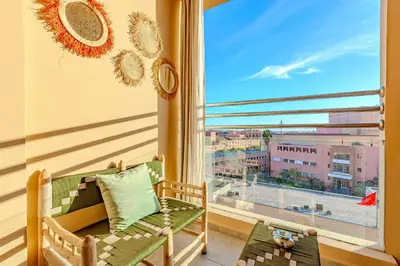 a room with a chair and a large window at GUELIZ city center Perfect location with nice view in Marrakech