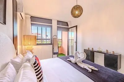 a bedroom with a large white bed with two swans on it at Manahil Modern Apartment Gueliz City Center in Marrakech