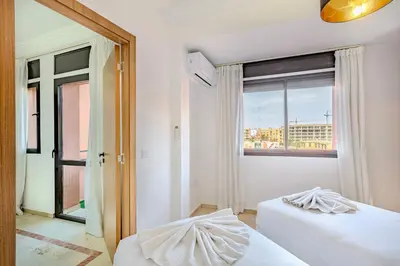 a bedroom with two beds and a large window at Manahil Modern Apartment Gueliz City Center in Marrakech