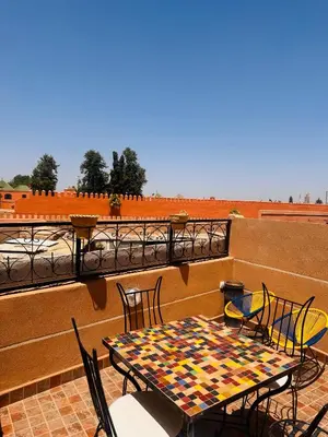 a table and chairs on top of a balcony at Lalla Mama medina house in Marrakech