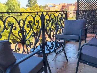 two chairs sitting on a balcony with a railing at Majorelle Apartment - Terrace Stunning Garden View in Marrakech