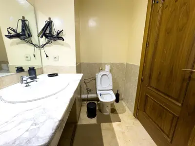 a bathroom with a sink and a toilet and a mirror at Majorelle Apartment - Terrace Stunning Garden View in Marrakech