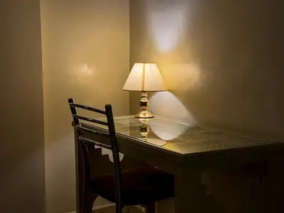 a lamp sitting on a desk with a chair at Majorelle Apartment - Terrace Stunning Garden View in Marrakech