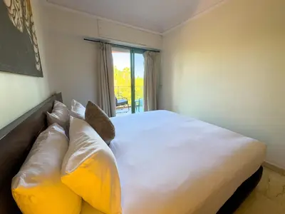 a bedroom with a large white bed with yellow pillows at Majorelle Apartment - Terrace Stunning Garden View in Marrakech