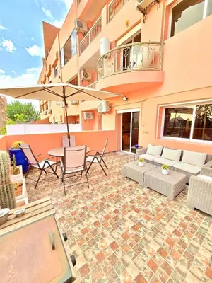 a patio with a couch and chairs and an umbrella at Joli et chic Appartement à Marrakech - balcon privé et confort in Oulad Akkou