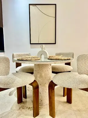 a table with four chairs and a picture on the wall at Résidence Ménara Garden Proche Gare & Jardins Ménara in Marrakech
