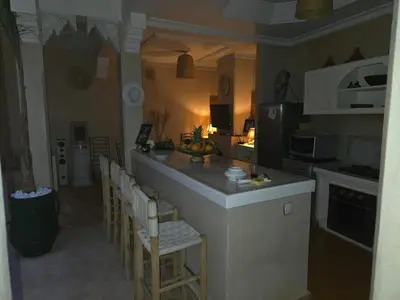 a kitchen with a bar with a bunch of chairs at Authentic Riad & Jacuzzi in Marrakech