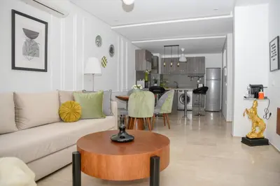 a living room with a couch and a table at Cozy One-Bedroom Apart Wi-Fi, Netflix, and Balcony in Marrakech