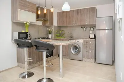 a kitchen with a table and a refrigerator at Cozy One-Bedroom Apart Wi-Fi, Netflix, and Balcony in Marrakech