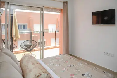 a living room with a couch and a view of a balcony at Cozy One-Bedroom Apart Wi-Fi, Netflix, and Balcony in Marrakech