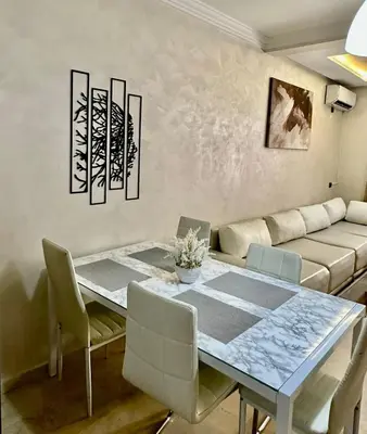 a dining room with a table and a couch at Moderne appartement centre Marrakech in Marrakech