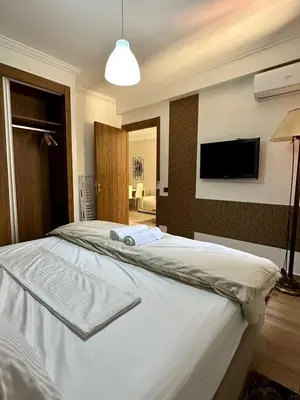 a bedroom with a bed with a tv on the wall at Moderne appartement centre Marrakech in Marrakech