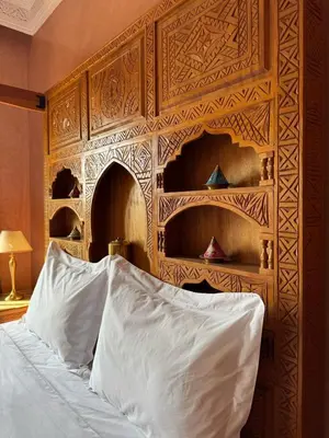 a bedroom with a bed with a wooden wall at Luxury Private Riad, Air-Conditioned and Pool in Marrakech