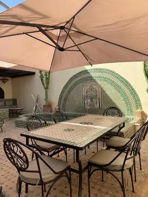 a table and chairs with an umbrella on a patio at Luxury Private Riad, Air-Conditioned and Pool in Marrakech