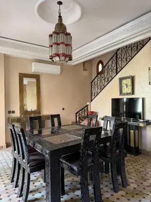 a dining room with a black table and chairs at Luxury Private Riad, Air-Conditioned and Pool in Marrakech