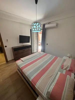 a bedroom with a bed and a flat screen tv at Studio au centre ville in Marrakech