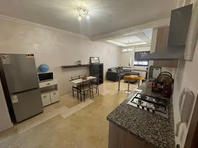 a kitchen and living room with a stove top oven at Studio au centre ville in Marrakech