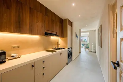 a kitchen with white counters and wooden cabinets at Pearl of Guéliz Netflix, Terrace, Quiet in Marrakech