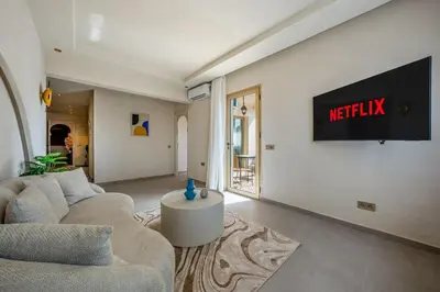 a living room with a couch and a television on a wall at Pearl of Guéliz Netflix, Terrace, Quiet in Marrakech