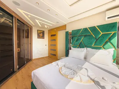 a bedroom with a white bed with a green wall at Essalmi Luxury Apartment in Marrakech in Marrakech