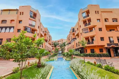 a street in a city with buildings and a canal at Luxe et sérénité avec jardin, terrasse et 5 piscines in Marrakech