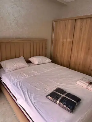 a bed with white sheets and a bag on it at Exceptionnel appartement a louer in Marrakech