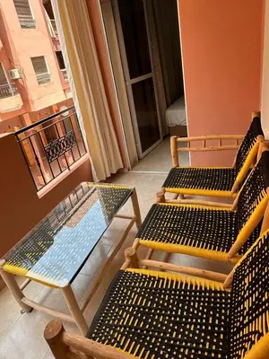 a balcony with two chairs and a glass table at Exceptionnel appartement a louer in Marrakech