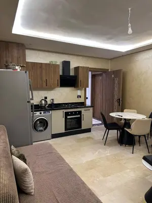a kitchen with a stove and a table with chairs at Pool View Quiet et Comfort in Marrakech