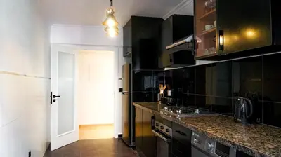 a kitchen with black cabinets and a white door at Majorelle Prestige in Marrakech