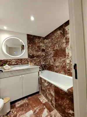 a bathroom with a tub and a sink and a mirror at Majorelle Prestige in Marrakech
