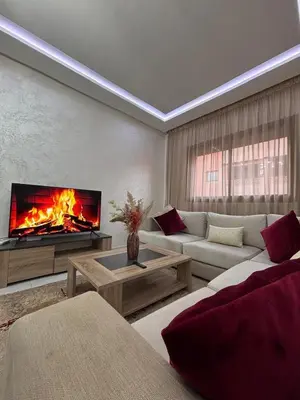a living room with a fireplace and a couch at La citrine in Marrakech