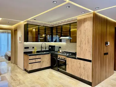 a kitchen with wooden cabinets and a stove top oven at Gueliz Terracotta Stay - 2 BR & Cozy Balcony in Marrakech