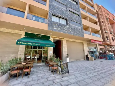 a restaurant with tables and chairs in front of a building at The Gueliz Escape - 2BR Luxury Flat in Marrakech