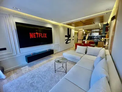 a living room with a white couch and a television at The Gueliz Escape - 2BR Luxury Flat in Marrakech