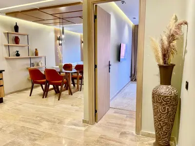 a dining room with a table and a vase at The Gueliz Escape - 2BR Luxury Flat in Marrakech