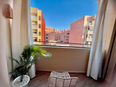 a balcony with two plants and a view of a city at The Gueliz Escape - 2BR Luxury Flat in Marrakech