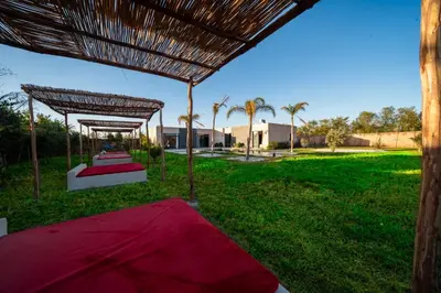 a bed with a canopy in a field of grass at Viva La Villa in Marrakech