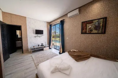a bedroom with a bed and a large window at Viva La Villa in Marrakech