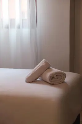 a towel sitting on the edge of a bed at Central Marrakech Apartment 2 Bedrooms Next to Majorelle Garden in Marrakech