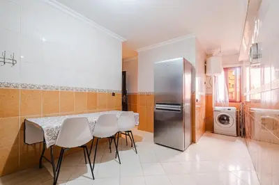 a kitchen with a table and a stainless steel refrigerator at Central Marrakech Apartment 2 Bedrooms Next to Majorelle Garden in Marrakech