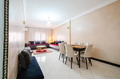 a living room with a table and chairs and a couch at Central Marrakech Apartment 2 Bedrooms Next to Majorelle Garden in Marrakech