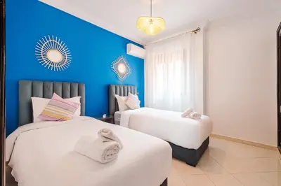 two beds in a room with blue walls at Central Marrakech Apartment 2 Bedrooms Next to Majorelle Garden in Marrakech