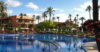 a large swimming pool with palm trees and a resort at Luxury apartement Palmeraie Village in Marrakech