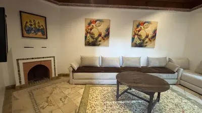 a living room with a couch and a fireplace at Luxury apartement Palmeraie Village in Marrakech