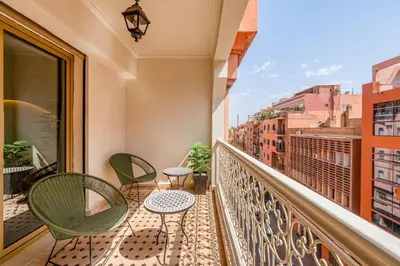 a balcony with chairs and tables on a balcony at Modern Haven Guéliz, Netflix, Comfort in Marrakech